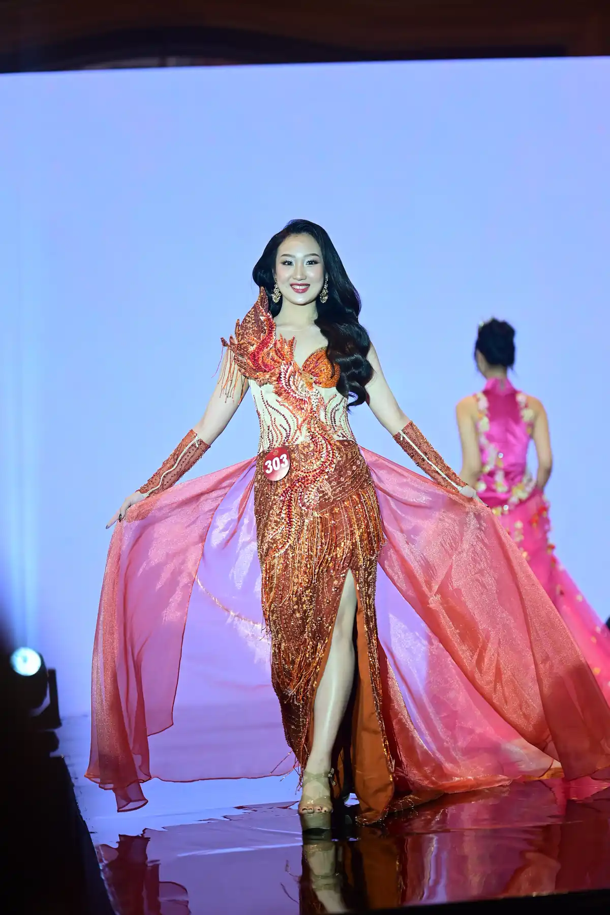Gebriella Giorgina melenggang di atas runway dalam balutan gaun malam merah keemasan